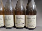 four bottles of wine are lined up on a table