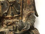 a small statue of a person sitting on a chair