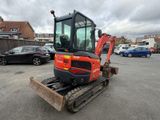 an image of a small excavator is parked in a parking lot