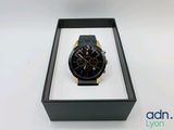 la montre se trouve dans un coffret noir posé sur une surface blanche