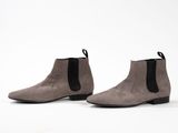 a pair of grey sued ankle boots with a black rubber sole