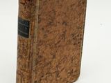 an old book sitting on top of a white surface