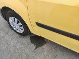 a small yellow car parked on the side of the road