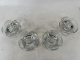 four glass ashtrays sitting on top of a white table