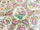 a close up of a table cloth with flowers and birds on it