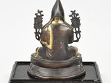 an old bronze statue of a man with a hat on top of a wooden base