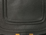 a close up of a black handbag on a white background