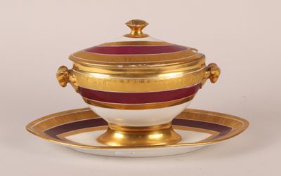 un bol et une soucoupe dorés et rouges, posés sur une soucoupe