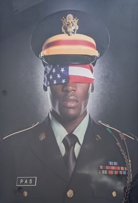 une affiche représentant un homme en uniforme militaire, le visage dissimulé par un drapeau américain