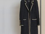 coat hanging on a clothes rack in front of a white wall