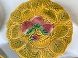 a yellow plate with a flower on it next to other dishes