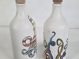two white bottles with designs on them sitting next to each other