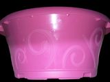 un récipient en plastique rose orné de motifs en spirale