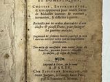 un vieux livre ouvert, sur lequel on peut lire des mots, posé sur une table