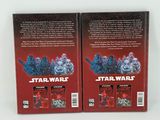 two star wars books are sitting on a white surface