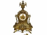 une horloge en or posée sur une table, à côté d'une clé