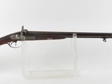 un vieux fusil au canon en bois, posé sur un socle transparent