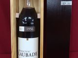 une bouteille de vin dans un coffret en bois sur fond rouge
