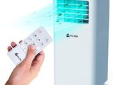 Quelqu'un tient une télécommande devant un petit climatiseur.