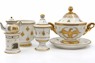 a white and gold tea set on a white table