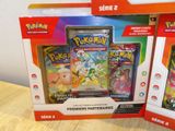two boxes of pokemon cards are sitting on a table