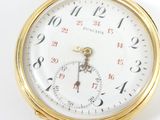 a close up of a pocket watch on a white surface