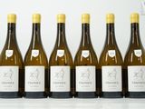 six bouteilles de vin sont alignées sur une table