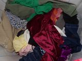 a pile of clothes sitting on a couch next to a christmas tree
