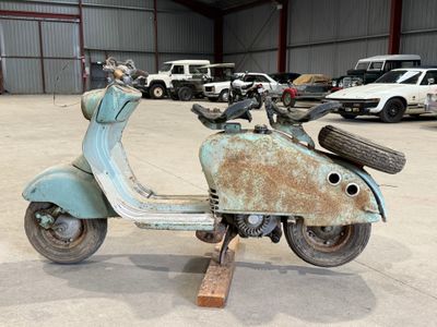 un vieux scooter qui traîne dans un garage