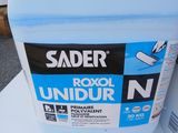 a container of sander next to a sign on a table