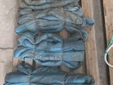 une pile de jeans posée sur une palette, à côté d'une paire de chaussures
