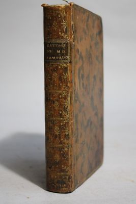 an old book sitting on top of a table next to a white table