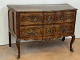 a small wooden chest of drawers on display in a room