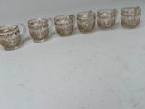 six glasses lined up in a row on a table