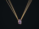 un collier en or orné d'une pierre améthorale sur fond noir