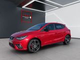a red seat ibe car parked in a showroom