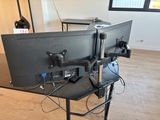 a desk with two monitors on it and a laptop on it