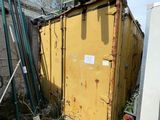 une benne à ordures posée à côté d'un immeuble