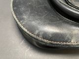 a close up of a black leather bag on a table