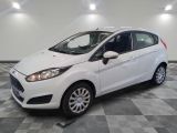 a white ford fiesta parked on a checkered tile floor