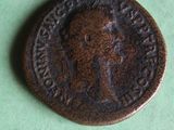 an old coin with a man on it on a green surface