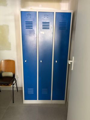 deux casiers bleus à côté d'une chaise dans une pièce