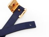 a close up of a blue leather belt with a gold buckle