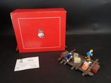 une boîte rouge sur laquelle sont représentées quelques petites figurines
