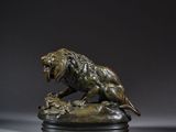 une statue en bronze représentant un lion sur un rocher