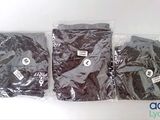 three bags of black clothing sitting next to each other on a white surface