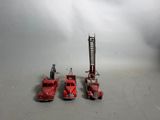 trois camions de pompiers miniatures posés les uns à côté des autres sur une table