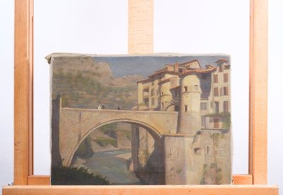 a painting on a easel with a picture of a bridge in the background