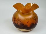 a glass vase with a painting on it on a table