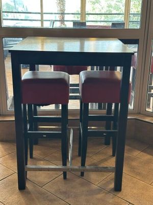deux tabourets rouges posés près d'une table au milieu d'une pièce